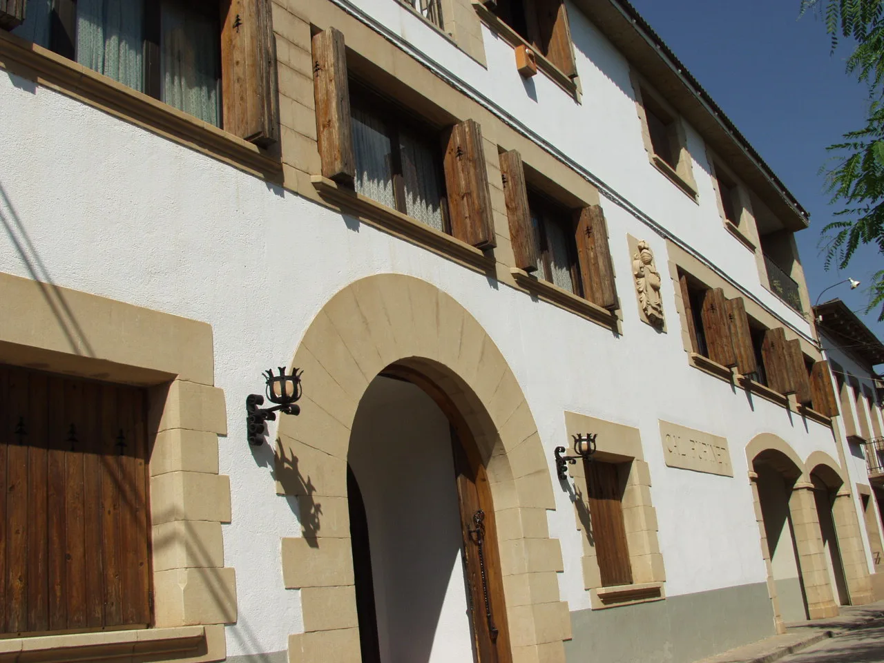 facana-masia-cal-pupinet Fachada de la masía Cal Pupinet, con arcos de piedra y ventanas de madera